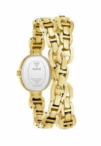 Arany színű rozsdamentes acél óra ovális fehér számlappal, masszív, láncszerű karkötővel összekötve. A számlapon és a hátlapon logóval rendelkezik.