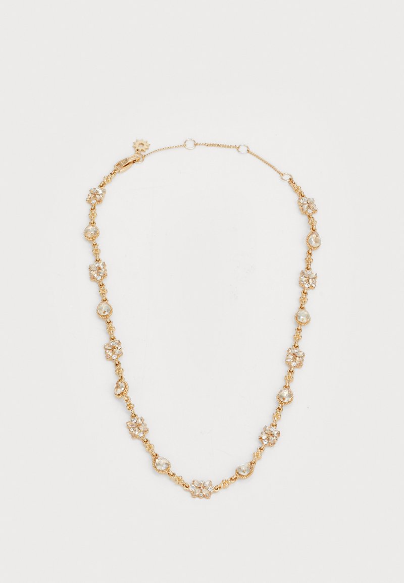 Guldtonet halskæde med runde og dråbeformede klare sten, prydet med blomstermotiver og en krabbe-lås. Elegant design med skiftende former.