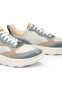 Zapatillas de cuero y ante en azul claro, beige y crema con detalles perforados, cordones blancos y suela gruesa blanca.
