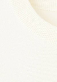Jopica z okrolim ovratnikom iz bombažne mešanice v brezčasno beli barvi, z rebrastim ovratnikom in teksturirano površino, ki izpostavlja gladko, mehko tkanino.