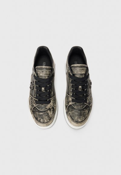 Worn-effect black leather sneakers with black laces, white soles, and "Roberto Cavalli" label on tongue, side metal embellishment visible.