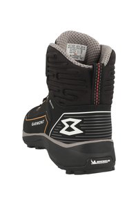 Černé a oranžové vysoké turistické boty s texturovaným svrškem, gumovou podešví a vyztuženým patkem. Obsahují značku GORE-TEX a logo Michelin.