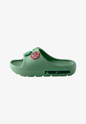 Groene schuimslof met verhoogde blokaccenten in rood en groen, een gestructureerd oppervlak en de tekst "MINCRAFT" aan de zijkant.