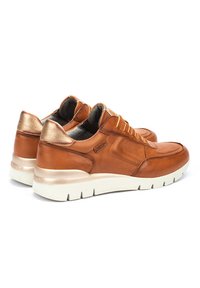 Zapatillas de cuero marrón con detalles texturizados, acentos dorados en el talón y una suela blanca de contraste. Diseño con cordones, cuello acolchado.
