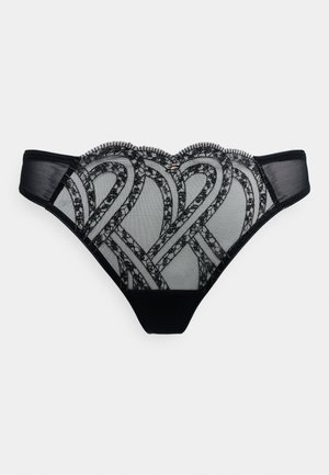 String noir en dentelle avec un motif détaillé complexe, des côtés en mesh transparent et une taille festonnée avec un panneau arrière en coton lisse.