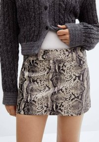 Skaft med slangeskindsdesign i beige og brun, lavet af glat materiale, har en tætsiddende pasform og en lige kant med bæltesløjfer.