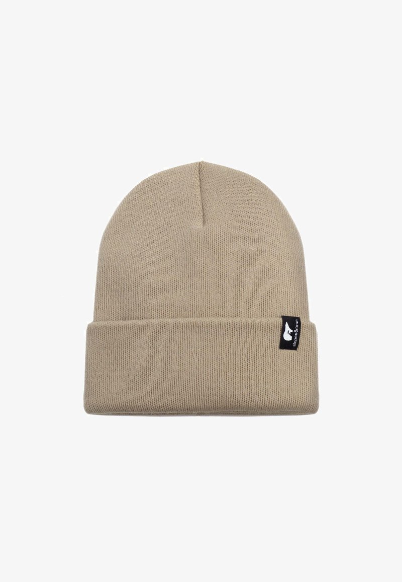 Berretto lavorato a maglia color beige con risvolto, dotato di un piccolo etichetta nera sul lato. Il materiale sembra morbido ed elastico.