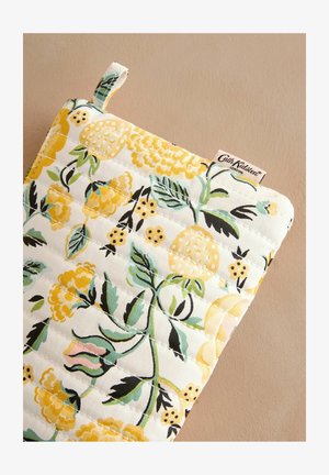 Pametan držač za lonce od pamučnog materijala s cvjetnim uzorkom koji sadrži žute cvjetove, zelene listove i voćne akcentne detalje na bijeloj pozadini. Ima omču za vješanje.