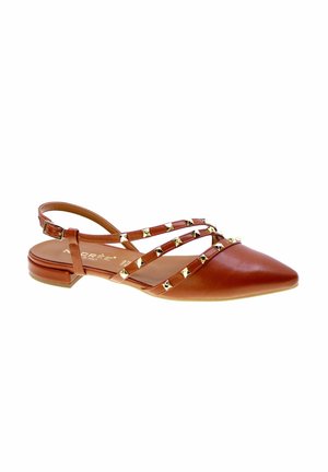 Scarpa piatta marrone a punta con tre cinturini borchiati sul davanti e un cinturino regolabile alla caviglia con una piccola fibbia.