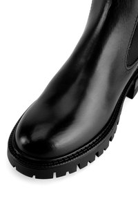 Czarne skórzane botki za kostkę o gładkim wykończeniu, zaokrąglonym nosku i grubym gumowym podBiciu z głębokim bieżnikiem dla lepszej przyczepności.