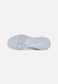 Witte sneakersole met een gestructureerd oppervlak met een hexagonaal patroon, cirkelvormige details en groeven voor grip. Geaccentueerd met oranje.