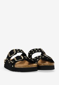 Sandalias de ante negro con dos correas ajustables y tachuelas doradas, plantilla de corcho y suela de plataforma para mayor altura.