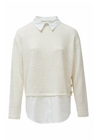 Pull-over blanc texturé avec des manches longues et un ourlet de chemise col. Présente des accents dorés sur le côté pour un détail et un contraste supplémentaires.