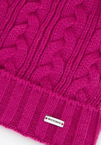 Ręcznie dziana czapka w intensywnym różowym kolorze z warkoczowymi wzorami i ściągaczem. Mała srebrna plakietka z napisem "WITTCHEN" na dole. Miękka w dotyku.