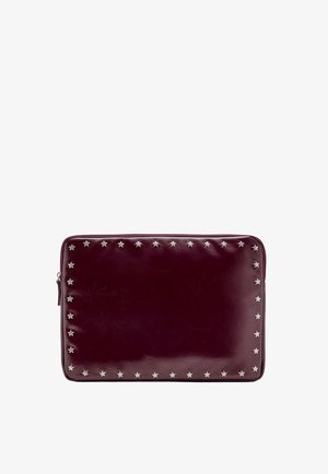 Pochette rectangulaire en cuir rouge foncé avec une fermeture éclair et de petits clous argentés en forme d’étoile bordant les contours avant.