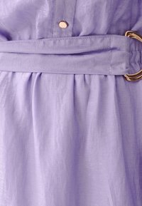 Lavender dress fabric with a textured finish, featuring a gathered waistline, gold-tone hardware, and a belt with a circular buckle.
