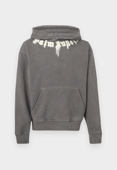Sweat à capuche gris avec une poche kangourou frontale. Présente un logo imprimé en texte blanc sur la poitrine. Texture douce, design décontracté.