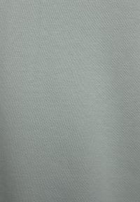 Tela de punto suave en azul claro con una textura fina. La tela muestra sutiles variaciones en el sombreado, típicas de un material de jersey.