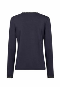 Tmavomodrý top s dlhým rukávom a okrúhlym výstrihom, ozdobený čipkovaným lemom na golieri a manžetách, vyrobený z hladkej bavlnenej látky.