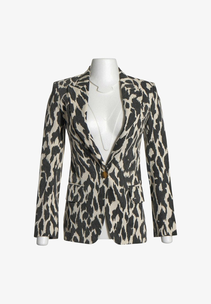 Blazer cintré imprimé animal noir et blanc avec une fermeture à un bouton et deux poches avant à rabat sur un mannequin torse blanc.