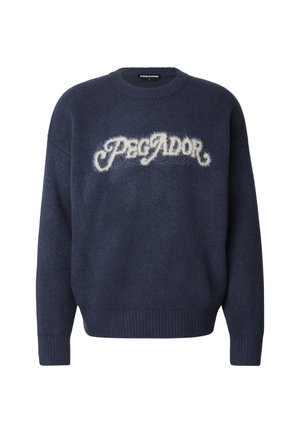 Strikket marineblå genser med rund hals, med fluffy hvit "PEGADOR"-tekst over brystet og ribbestrikkede mansjetter og kant.