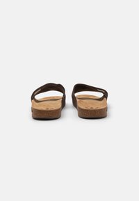 Chinelos de borracha castanhos com uma alça superior texturizada e um pé de cortiça acolchoado. Sola plana com uma discreta impressão do logótipo da marca na palmilha.