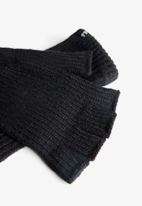 Guanti senza dita neri a maglia con un motivo testurizzato, dotati di bordi a coste e un piccolo logo sul polsino. Materiale morbido e caldo.