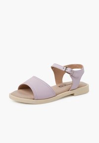 Lilac sandal featuring two wide straps, open toe design, adjustable ankle buckle, and a light beige sole with textured footbed.