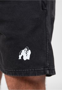 Zwarte shorts van katoen met een gestructureerde afwerking. Heeft een witte gorilla graphic op het onderste linkerbeen.