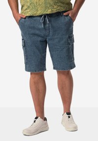 Denim cargo shorts i medium blått, med sidfickor och snörning i midjan, tillsammans med vita träningsskor. Avslappnad design.