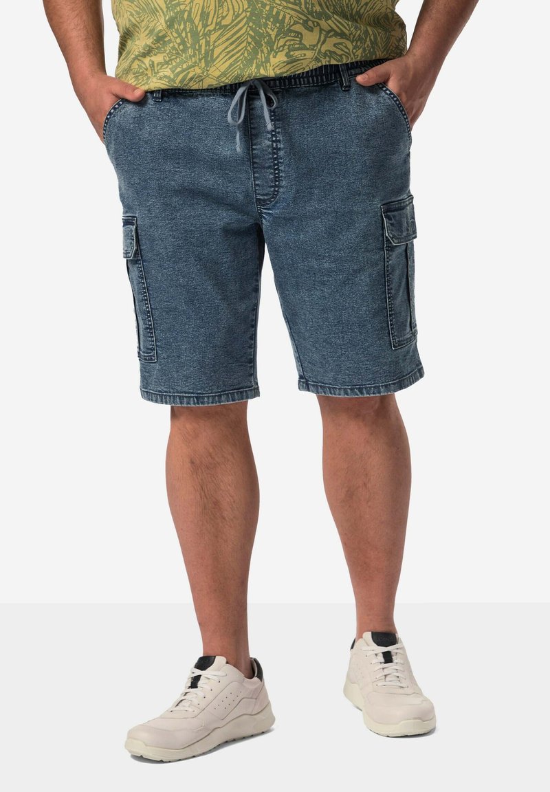 Denim cargo shorts i medium blått, med sidfickor och snörning i midjan, tillsammans med vita träningsskor. Avslappnad design.