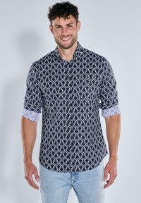 Schwarz-weiße gemusterte Hemd mit Kentkragen, langen Ärmeln und kontrastierenden hellblauen Manschettendetails. Lässiger Schnitt.