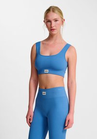 Niebieski sportowy stanik w prążki z szerokimi ramiączkami i kwadratowym dekoltem, w zestawie z dopasowanymi legginsami w wysokim stanie z logo.
