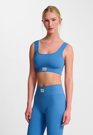 Blauer, gerippter Sport-BH mit breiten Trägern und quadratischem Ausschnitt, kombiniert mit passenden, hochtaillierten Leggings mit einem Markenpatch.
