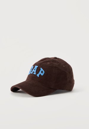 Кафява бейзболна шапка от рипсено кадифе с извита козирка и голям надпис GAP в синьо, показана на изчистен светъл фон.