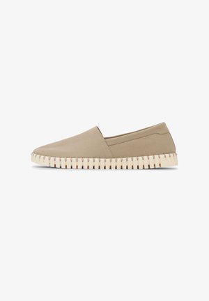 Beiger Slipper mit glattem Obermaterial und dicker weißer Sohle mit tiefen, gleichmäßig verteilten Rillen.