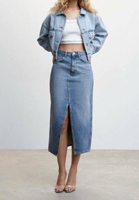 Giacca di denim e gonna lunga coordinata in denim, blu chiaro, stile aderente, con dettaglio di spacco davanti, abbinata a tacchi trasparenti, texture liscia.