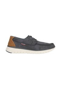 Chaussure en suede grise avec un accent marron au talon. Présente des lacets ronds et une semelle blanche épaisse. Marque visible sur le côté.