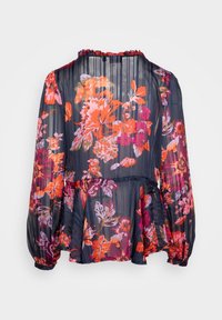 Blouse fluide navy à motifs floraux avec des motifs vibrants d'orange et de rose. Dotée de manches longues, d'un col froncé et d'un design en peplum superposé.