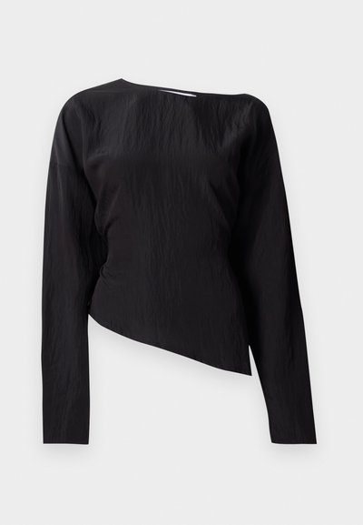 Musta pitkähihainen paita, jossa on tekstuuripinta, epäsymmetrinen muotoilu ja korkea kaula-aukko. Yhdellä puolella on hieman laskostusta.