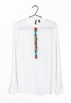 Camicia bianca a maniche lunghe con colletto rotondo e un pannello di perline multicolori lungo la parte anteriore. Tessuto morbido con chiusura a bottone sul collo.