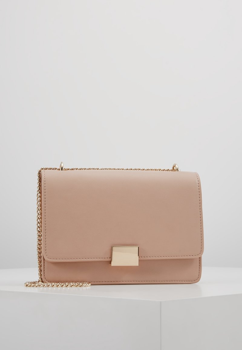 Borsa a mano in pelle rosa chiaro con tracolla in catena dorata, forma rettangolare, falda frontale e chiusura in metallo dorato. Texture liscia, design minimale.