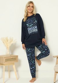 Granatowy zestaw piżamowy z długim rękawem z napisem "DREAM EXPLORER" oraz legginsami w wzory niebieskozielonych motywów kosmicznych.
