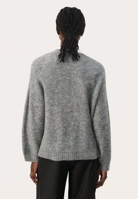 Siv oden knit pulover s sproščenim krojem, ki ima rahlo puhasto teksturo, spuščenimi rameni ter rebrastimi manšetami in robom.
