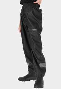 Zwarte waterdichte broek met elastische tailleband, reflecterende accenten en een losse pasvorm, gemaakt van soepel, duurzaam materiaal.
