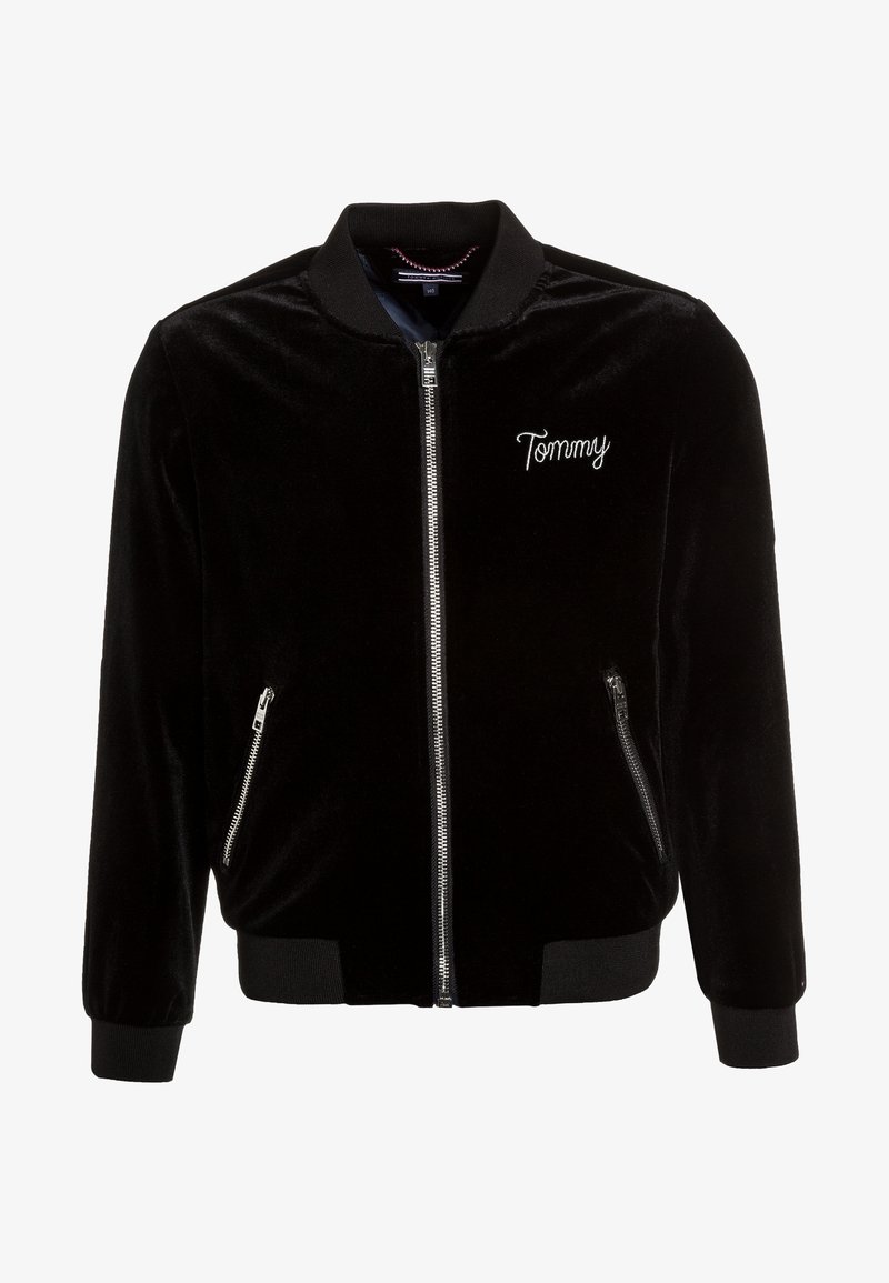 Svart sammet bomberjacka med dragkedja fram, ribbade ärmslut och nederkant, sidofickor och broderad "Tommy" på bröstet.