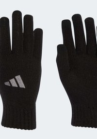 Černé pletené rukavice s vroubkovanými manžetami, zdobené šedým logem Adidas na zápěstí a texturovaným povrchem pro lepší úchop.