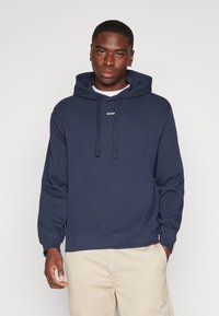 Felpa con cappuccio blu navy realizzata in tessuto morbido, dotata di cappuccio con cordino e piccolo logo bianco sul petto. Design semplice, vestibilità regolare.