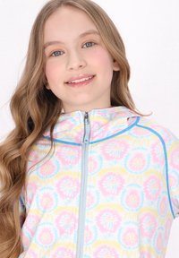 Felpa leggera con zip in colori pastello e motivo floreale. Caratterizzata da un cappuccio e una zip blu a contrasto, mostra una texture di tessuto liscia.