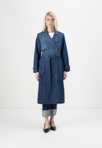 Jeans trenchcoat med dobbeltradet design, blå farge, belte i livet og skulderklapper. Har lange ermer og lengde til midten av leggen.